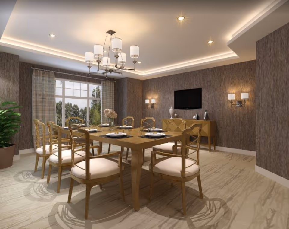 Dining room with a long wooden table set with plates, cushioned wooden chairs, a chandelier, a sideboard with a wall-mounted TV, and a large window.
