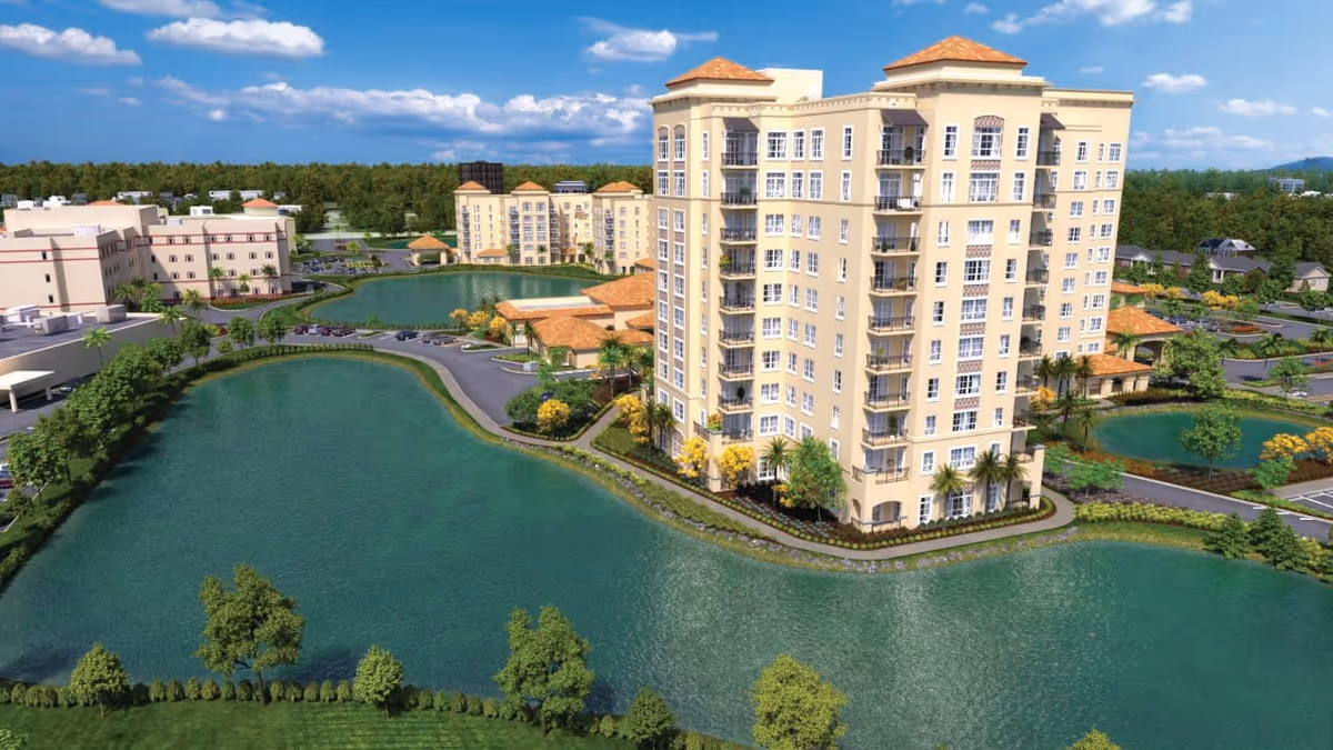 Aerial view of a senior living facility named The Levin Palace featuring multiple multi-story beige buildings with red-tiled roofs surrounded by landscaped grounds and several large ponds under a partly cloudy blue sky.