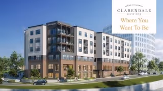 Exterior view of a modern multi-story senior living facility named Clarendale West End, featuring balconies, large windows, and a landscaped area with trees and parked cars under a clear blue sky.