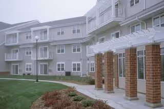 Exterior view of Parkside Commons Senior Apartments showing brick entry pillars and lawn.
