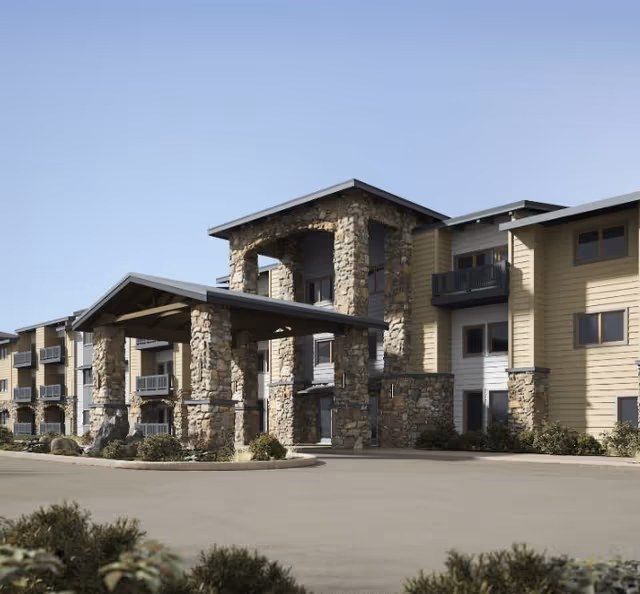 Exterior view of Hearthstone Lodge Senior Residences building with stone pillars and entryway.