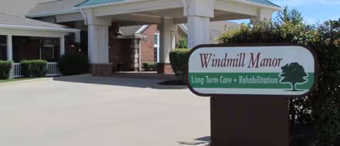 The Windmill Manor entrance features a sign and porte-cochere overhang at the front.