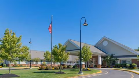 Exterior view of Atlas Healthcare Washington Township building with entrance, flag, trees, and manicured grounds.