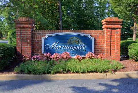 Brick entrance sign reading Morningside with flowering shrubs nearby.