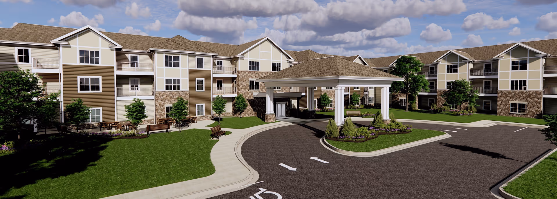 Exterior view of a senior living facility named Lockwood of Lyon featuring a large three-story building with beige and brown siding, stone accents, multiple windows, balconies, and a covered entrance with a circular driveway. The landscaped grounds include green lawns, trees, benches, and flower beds under a partly cloudy sky.