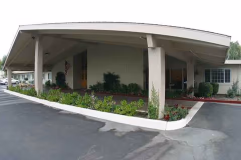 Front entrance of Cedar Crest Nursing and Rehabilitation Center with a covered drive-through and landscaping.