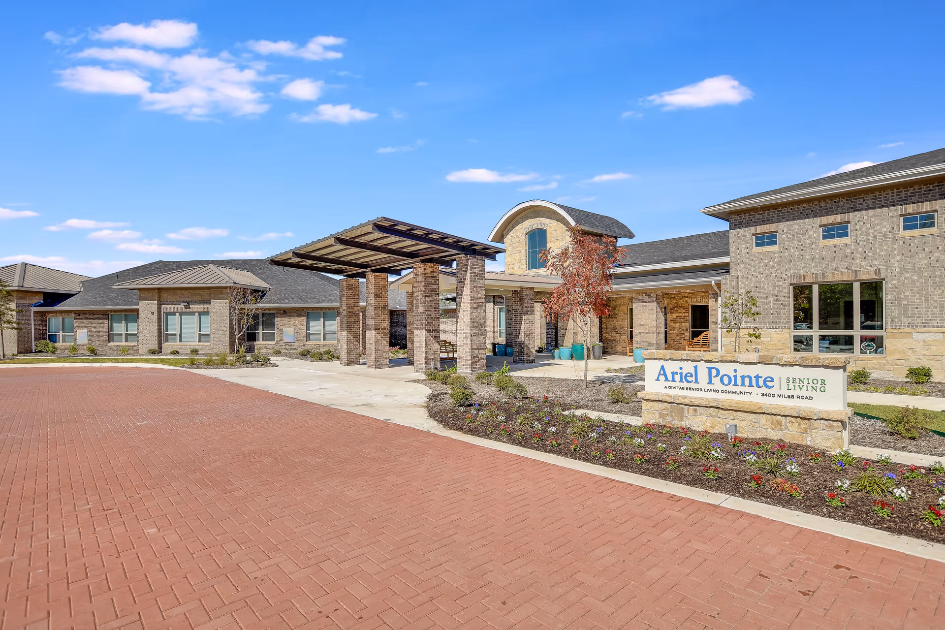 Exterior view of Ariel Pointe Senior Living with entrance canopy and landscaped signage.