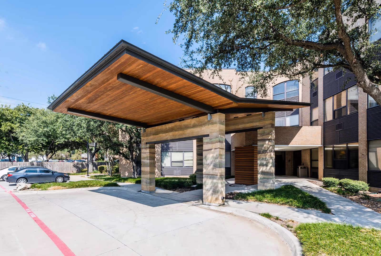 Walnut Place senior living facility exterior with wooden canopy entrance and parked cars.