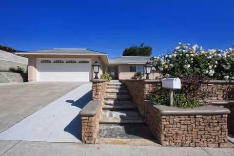 Stone-walled steps and driveway lead to Verona Court exterior entrance.