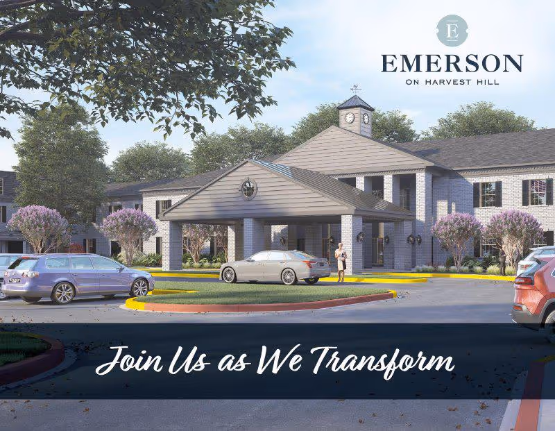 Exterior view of Emerson on Harvest Hill senior living facility showing a two-story building with a covered entrance, cars parked in front, trees, and landscaping under a clear sky.