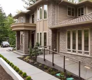 Brick and stone senior living building exterior with large windows and accessible entrance.
