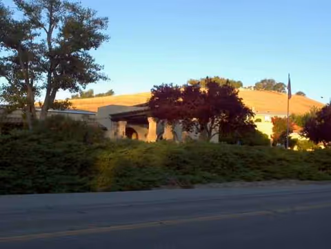 Exterior view of a facility with landscaping along a road