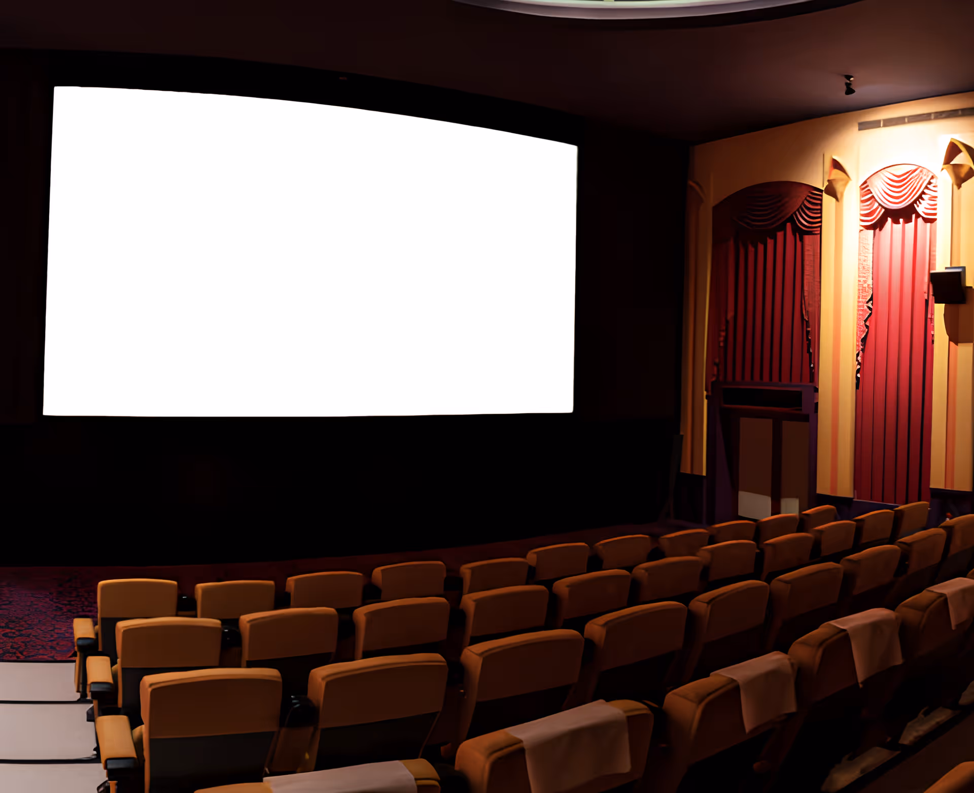 Empty movie theater screening room with rows of seats facing a large blank screen and decorative side curtains.