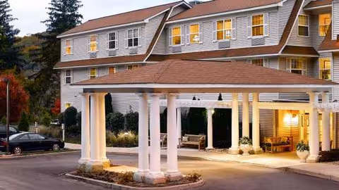 Atria Briarcliff Manor exterior with a porte-cochère entrance and illuminated windows.