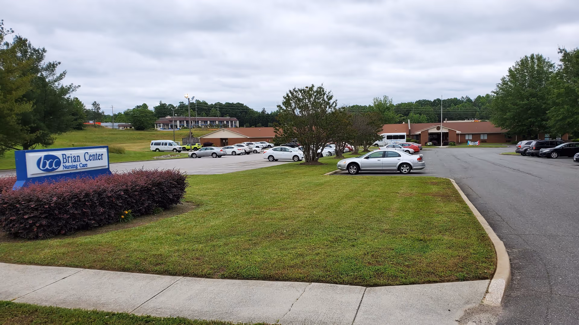 Parking lot and lawn in front of a senior care center building.
