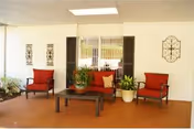 Lobby seating area with red chairs, a coffee table, and potted plants.