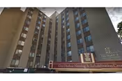 Tall multi-story nursing home exterior with red signage at the entrance.