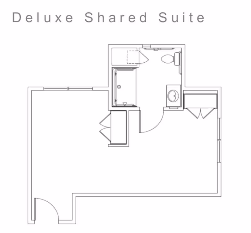 Architectural floor plan of a deluxe shared suite showing a layout with a bathroom including a toilet, sink, and shower, and an adjoining living/sleeping area with closets and entry door.