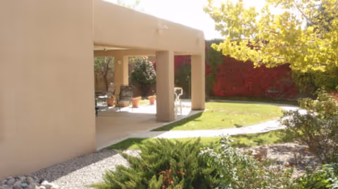 Exterior view of Haven Care facility with a shaded patio and outdoor seating area.