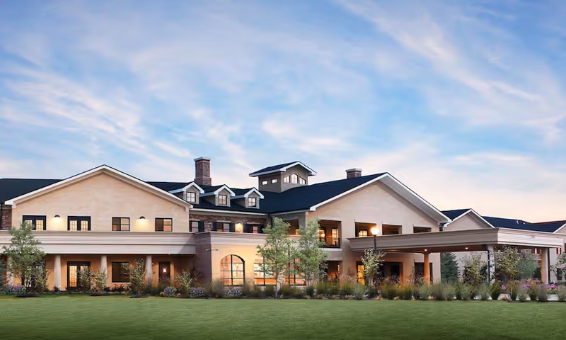 Exterior view of HarborChase of Plano senior living facility with lawn