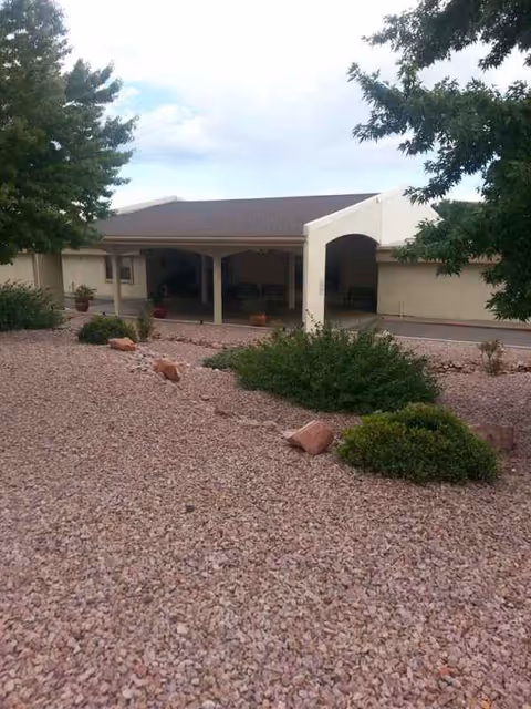 Exterior view of Mountain View Manor's front entrance with gravel landscaping and shrubs.