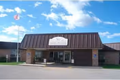 Front view of Christian Park Healthcare Center with brick facade, brown roof, flagpole, and entrance.