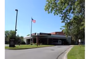 Exterior view of Edgewood Grand Forks building entrance with American flag and landscaped surroundings.
