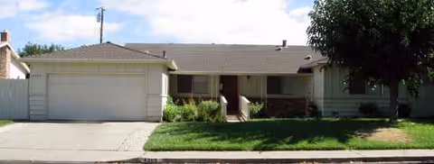 Front exterior of Qcare Residential Facility III, showing a single-story building, yard, and garage.