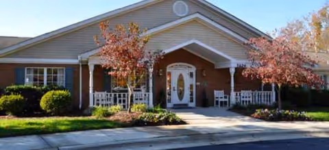 Front entrance of Brookdale South Park with brick facade and red-leaf trees.