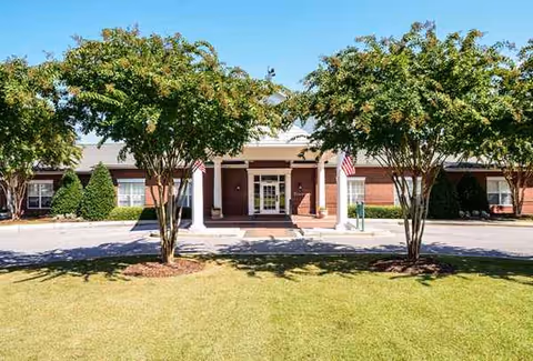 Exterior view of The Haven in the Summit entrance with trees and a grassy lawn.