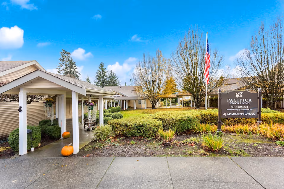 Exterior view of The Cottages of Snohomish senior living with flag and sign