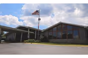 Front exterior of Holston Rehabilitation and Care Center with flagpole and large glass windows.