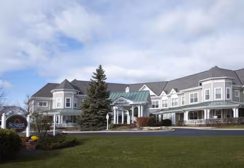 Exterior of a large, multi-wing senior living building with a manicured lawn.