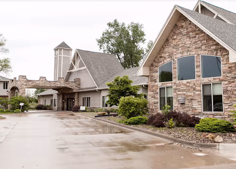 Exterior view of Charter Senior Living of Moline with stone facade and driveway.