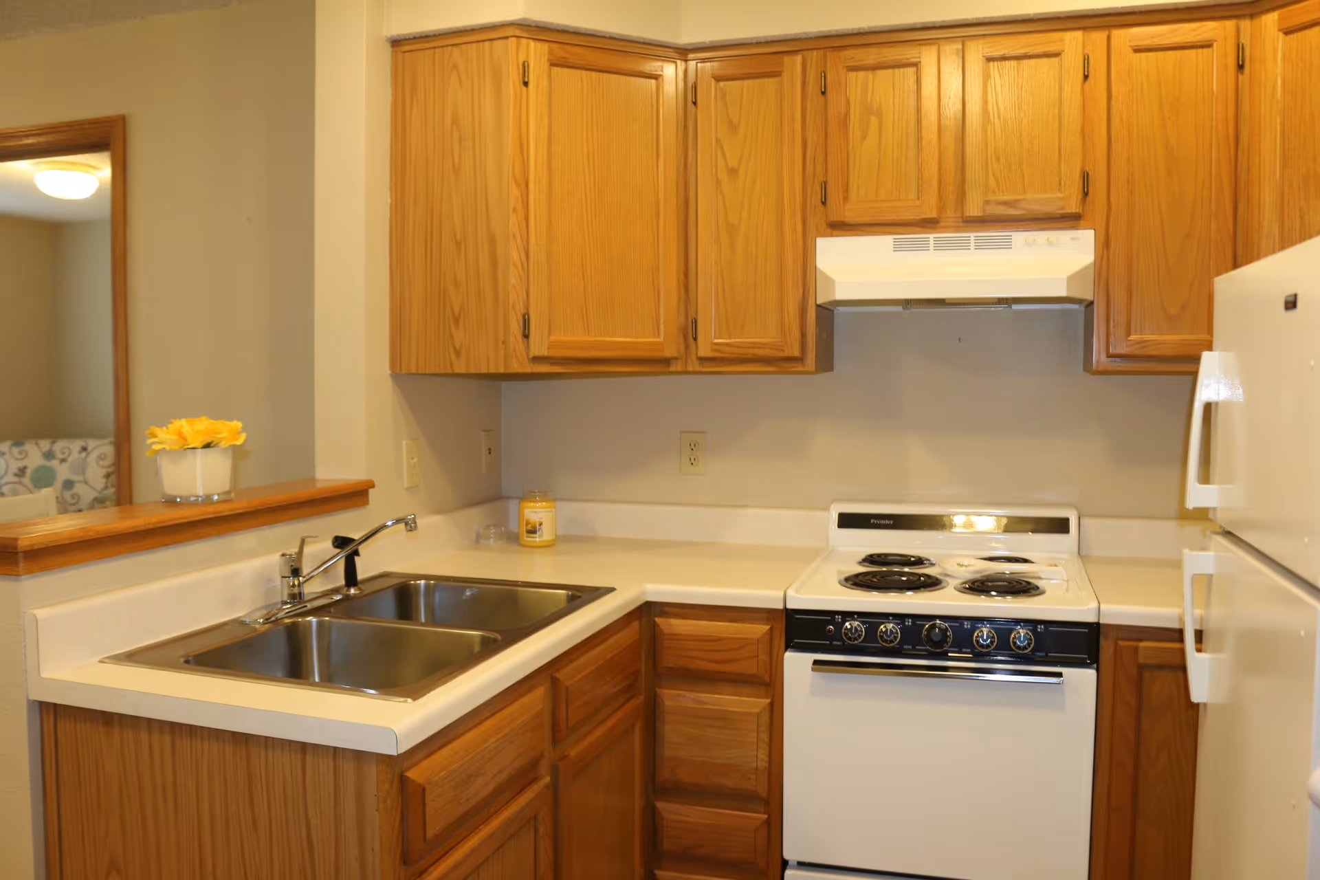 Kitchen featuring oak cabinets, a double stainless sink, a white electric stove with hood, and a refrigerator.