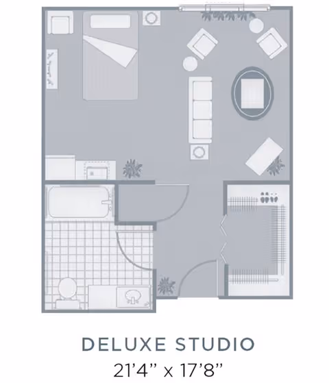 Floor plan of a deluxe studio apartment measuring 21 feet 4 inches by 17 feet 8 inches, showing a combined living and sleeping area with a bed, sofa, chairs, and tables, a bathroom with a bathtub, toilet, and sink, and a closet area.
