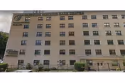 Beige, multi-story building labeled Fairview Rehab & Nursing Home with numerous windows.
