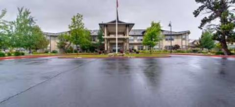 Brookdale Redmond senior living facility seen from a wet parking lot toward the front entrance