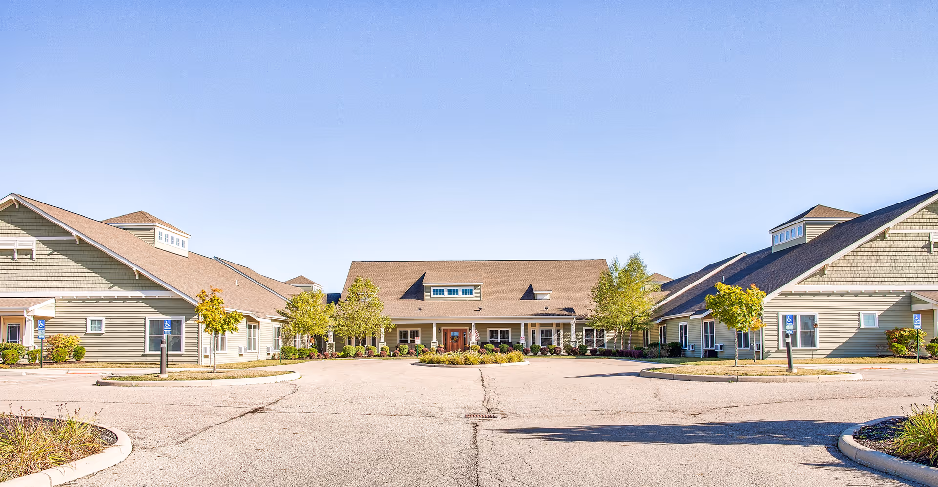 Exterior view of Landings of Sidney senior living facility with driveway and landscaping.