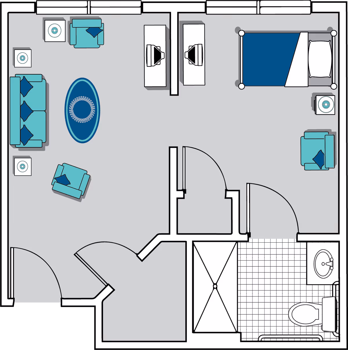Floor plan of a senior living unit at Oaks at Ellijay showing a living room with sofa, two armchairs, and a rug, a bedroom with a bed, armchair, and nightstand, and a bathroom with a shower, toilet, and sink.