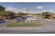 Exterior view of Shore Health and Rehabilitation Center with parking lot and landscaped island.