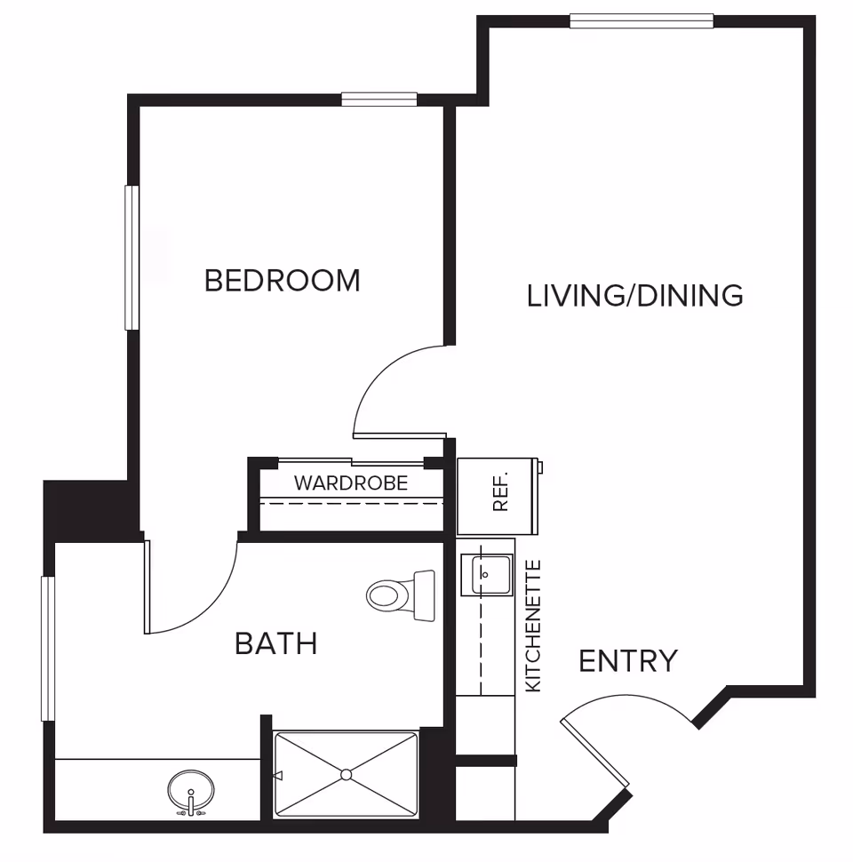 Floor plan of a one-bedroom apartment at Carmel Village showing a bedroom, bathroom with shower and toilet, wardrobe, kitchenette with sink and refrigerator, living/dining area, and entryway.