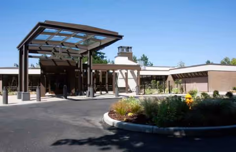 Exterior view of Kline Galland Home with a covered entrance and landscaped circular driveway.