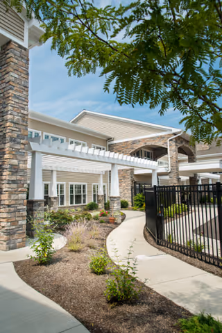 Exterior view of Manchester Commons with landscaped entry, stone accents, and a gated walkway.