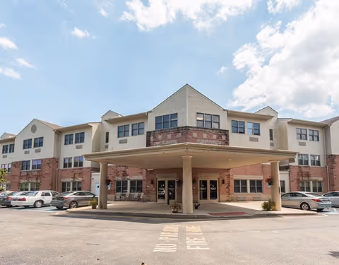Exterior view of Spring Oak at Forked River with the entrance and parked cars.