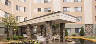 Exterior view of Silver Healthcare front entrance with covered drop-off and benches.