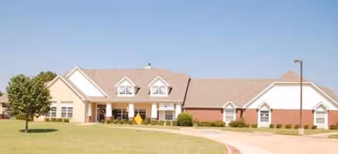 Exterior view of Brookdale Stillwater building with lawn, driveway, and clear blue sky.