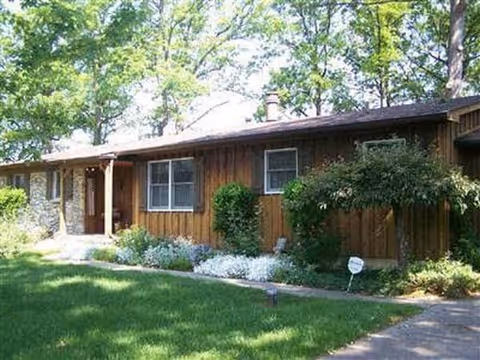 A single story wooden senior living facility exterior with a manicured lawn.