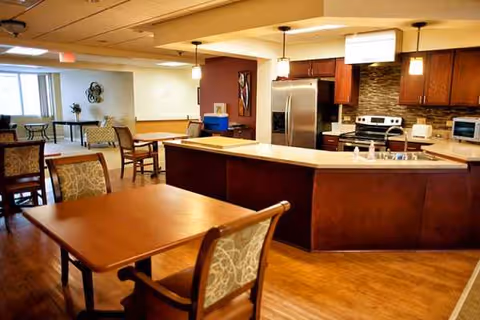 Spacious communal kitchen and dining area with island, pendant lights, and wooden tables.