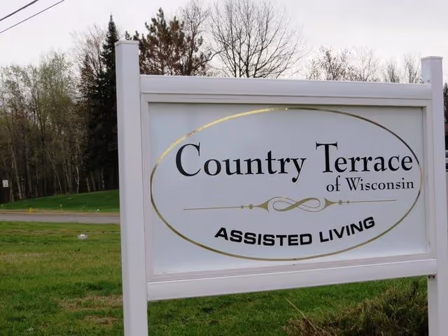 Outdoor sign displays Country Terrace of Wisconsin, an assisted living facility.